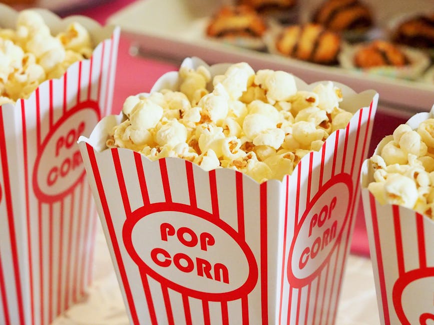 Close-up of gourmet popcorn in classic red and white striped boxes, perfect cinema snack.